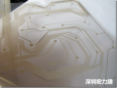 下面第二個(gè)圖則是另一片也有著按鍵線路的PTF，當(dāng)上、下兩面PTF的按鍵結(jié)點(diǎn)互相接觸后就可以計(jì)算出是哪個(gè)按鍵被按下了?？墒钱?dāng)按鍵沒有按下時(shí)，上下兩片PTF的線路則是分開的，所以上圖那片PTF的線路上面其實(shí)還另外覆蓋了另一層透明的PET作為絕緣層，只露出了需要在鍵盤按下時(shí)才會(huì)碰觸的接觸點(diǎn)，因?yàn)檫@些材質(zhì)使用的都是Polymer，所以才撐這樣的技術(shù)為Polydome(聚合簧片)。